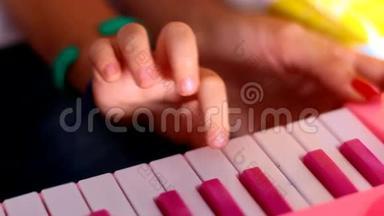 宏小指<strong>一个</strong>接<strong>一个</strong>地<strong>按下</strong>粉红色钢琴的键
